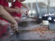 Volunteers fry up sausages for the thousands of people who took advantage of the free breakfast sponsored by Fred Meyer on the opening day of the Clark County Fair.