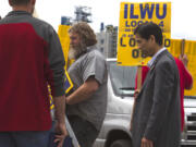 Fusao Ohori, right, a Japanese union leader visiting from Tokyo, joined union dockworkers Friday outside the United Grain Corp.