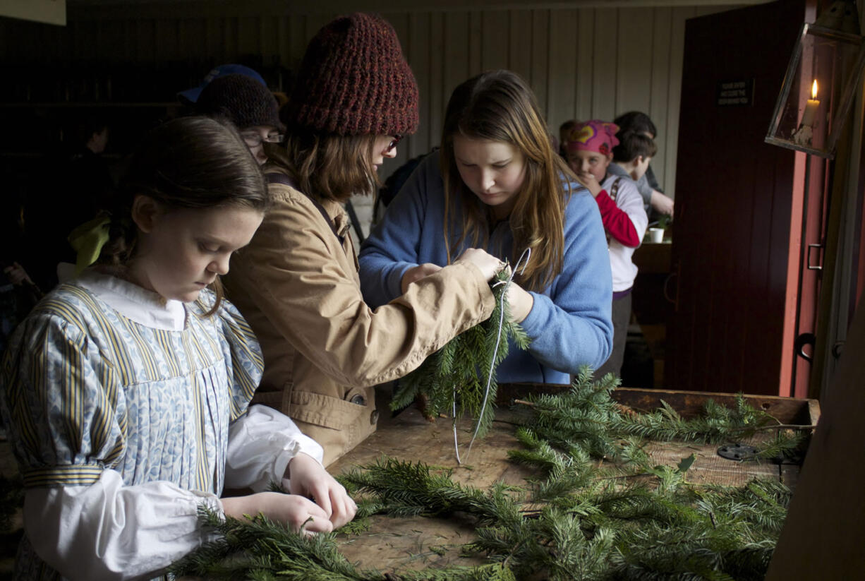 Fort volunteer Margaret Kerby, left, makes wreaths with Emily Winterham, center, and Camille Shelton at the Christmas at the Fort event last year.