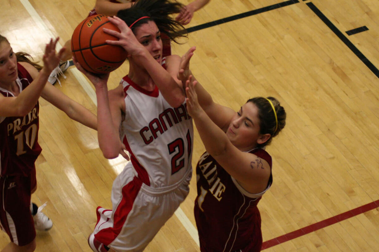 Lauren Neff soars over three Falcons and scores a basket for the Papermakers Friday, in Camas.