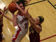 Lauren Neff soars over three Falcons and scores a basket for the Papermakers Friday, in Camas.