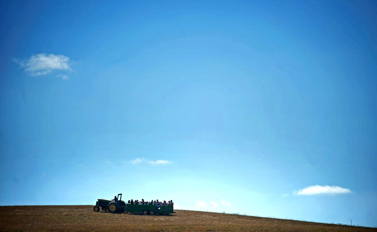 Visitors get a tractor ride during the 9th Annual Harvest Fun Day at Heritage Farm on Saturday.