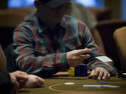 A poker player folds during a Texas Hold 'Em tournament at the Oak Tree Casino in February.