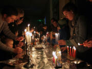 Members of Congregation Kol Ami, including Lauren Trexler, at right, light candles on menorahs Sunday evening to celebrate Hanukkah.