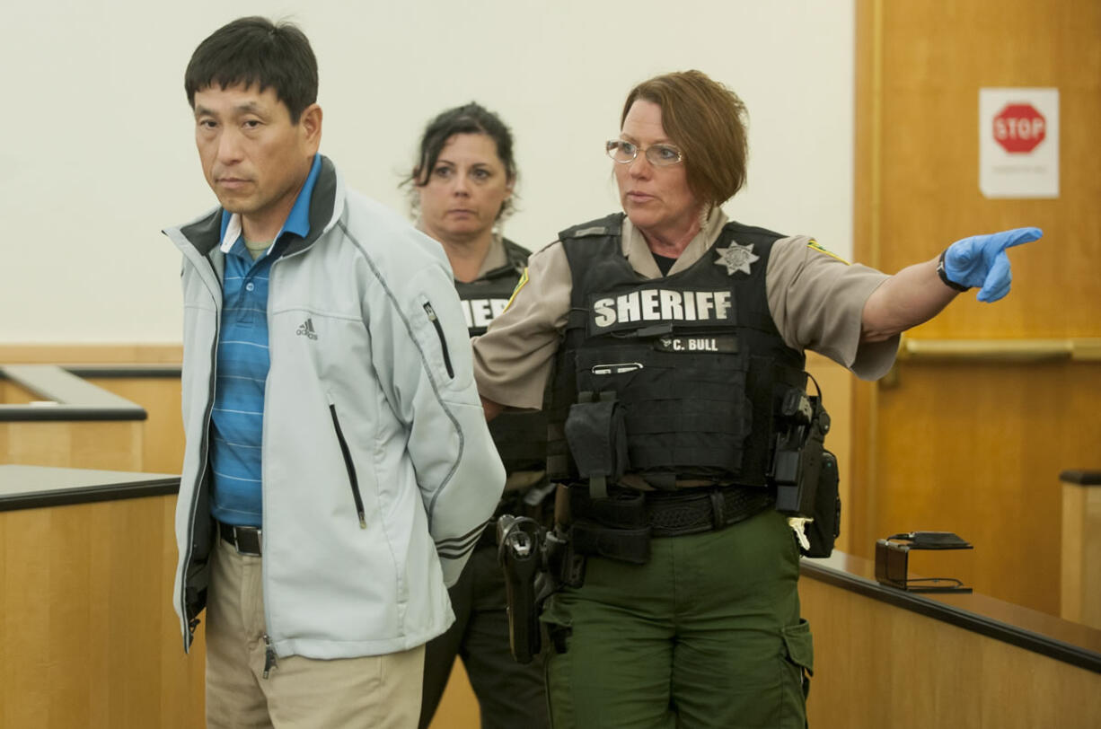 Kooyeoll &quot;Eric&quot; Jung is led away in handcuffs after changing his plea in Clark County Superior Court on Oct. 29. Jung was sentenced Tuesday to 15 months in prison for indecent liberties.