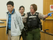 Kooyeoll &quot;Eric&quot; Jung is led away in handcuffs after changing his plea in Clark County Superior Court on Oct. 29. Jung was sentenced Tuesday to 15 months in prison for indecent liberties.