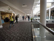 Zachary Kaufman/Columbian files
Shoppers walk past the Vancouver Mall Community Library. Starting Monday, it will be closed for about three months. A smaller version will open in about the same location as the Mall Library Connection.