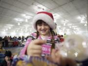 Larissa Crandall, 8, of Vancouver, wraps a donated Christmas gift for a local child.