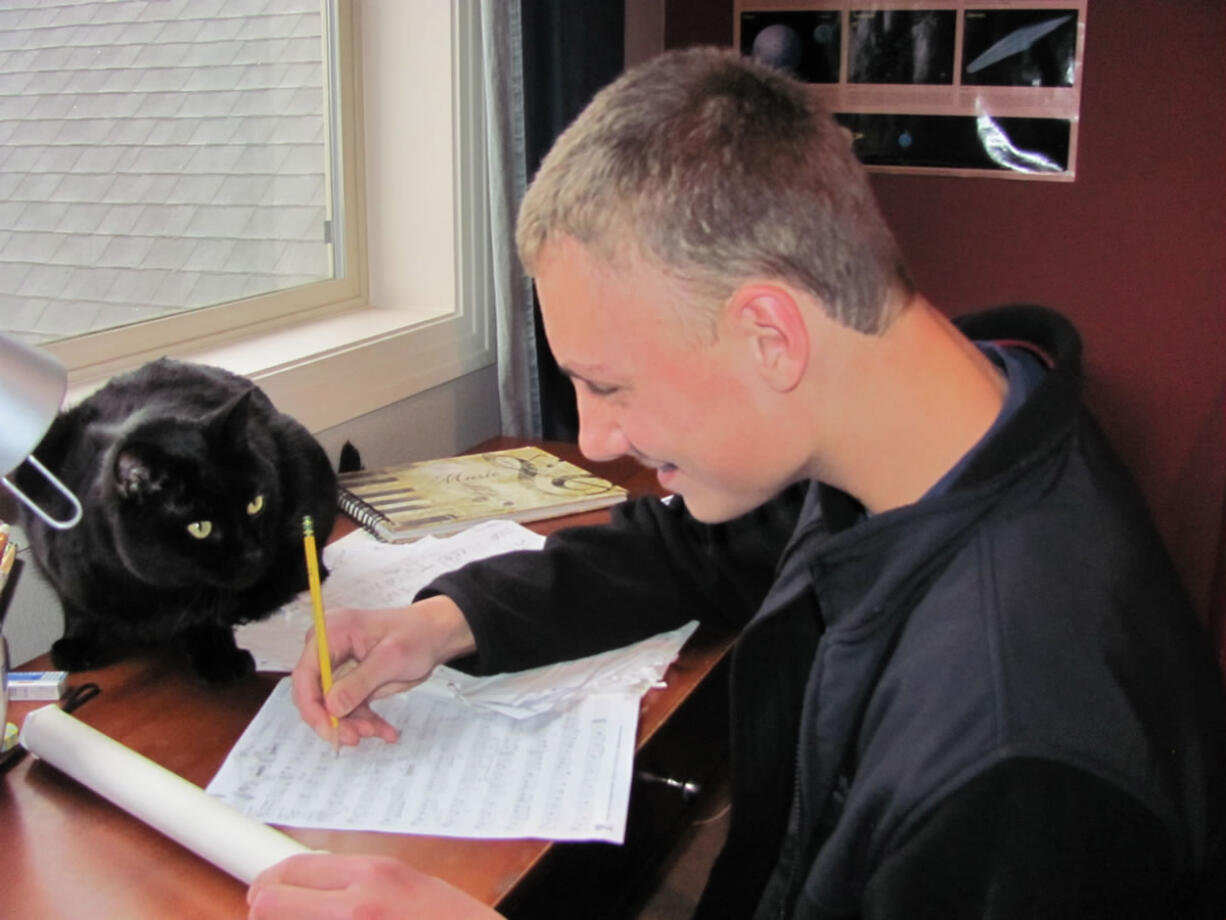 Neumann's cat, Kanga, is a constant companion at his desk while he composes music.