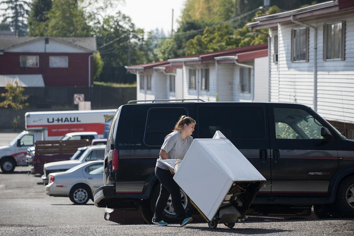 Ghim Village resident Tiffany Shepherd makes her way through the parking lot with her washer on Sept. 30. A friend who&#039;d borrowed the washer was moving out. Residents of the low-income complex were given 22 days notice to leave, forcing them to find new housing during a time of rising rents and low vacancy rates.