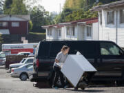 Ghim Village resident Tiffany Shepherd makes her way through the parking lot with her washer on Sept. 30. A friend who&#039;d borrowed the washer was moving out. Residents of the low-income complex were given 22 days notice to leave, forcing them to find new housing during a time of rising rents and low vacancy rates.