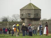 Children play hoops and rings Saturday beneath a veil of drizzle at the Christmas at the Fort celebration.