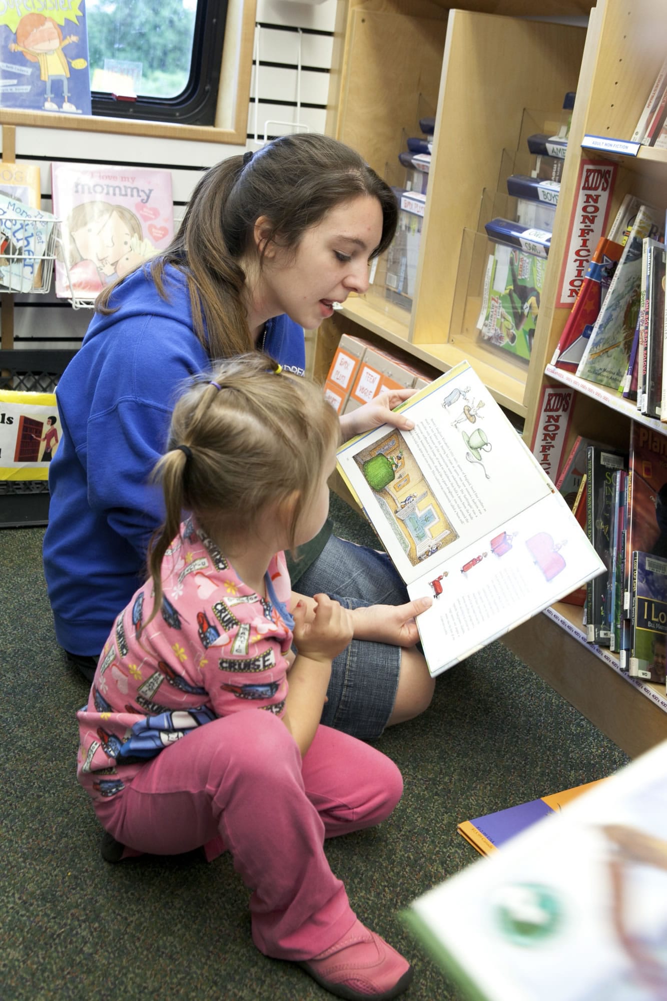 Stephanie Paulson, who works with preschoolers from Country Friends Daycare, reads aloud in the bookmobile as it makes its final stop Friday morning in Hockinson.