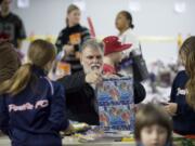 Brian Stansberry wraps Christmas presents as part of Santa's Posse. He and his wife learned of the program from a granddaughter and decided to go volulunteer.