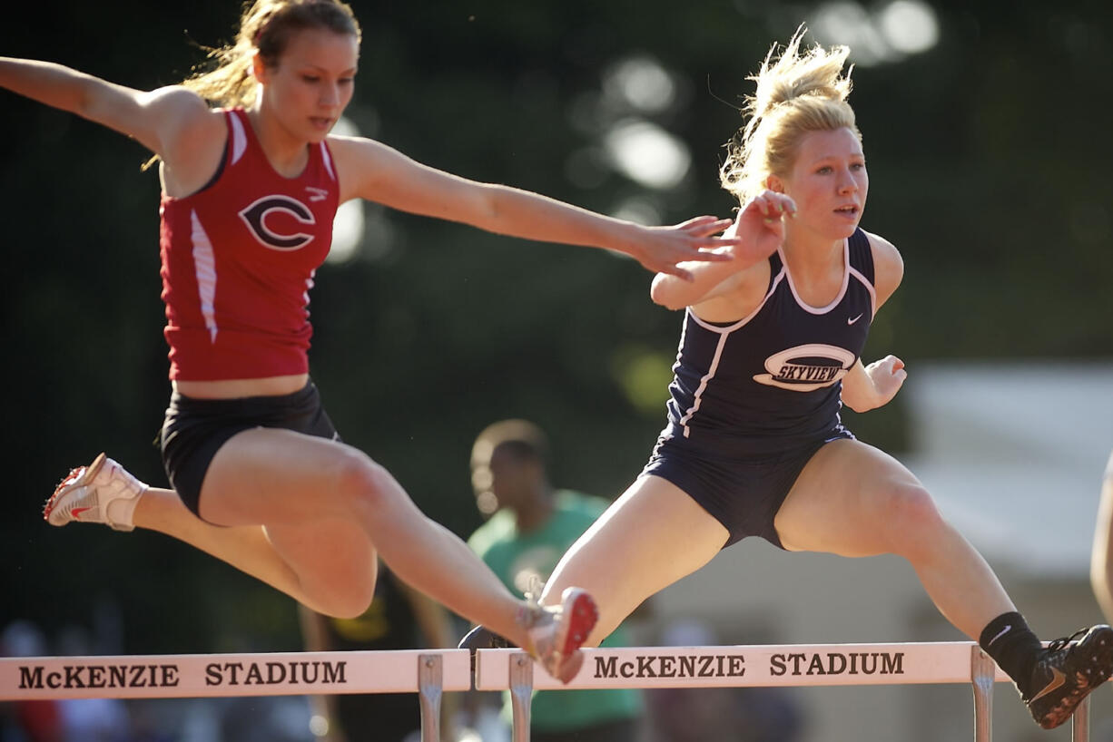 Jordan Davis, left, of Camas High School, and Madison Lanford of Skyview High School, compete in the girl's 300 meter hurdles at the 4A District Track and Field meet Wednesday May 8, 2013 in Vancouver, Washington at McKenzie Stadium. Lanford won with a time of 45.73.