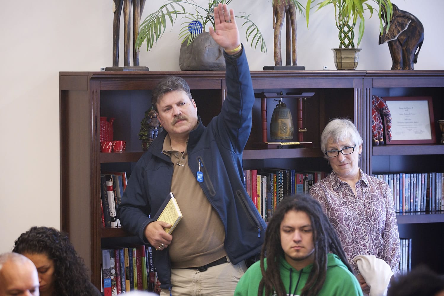 Brian Myers of Vancouver raises his hand before speaking Tuesday at a Clark College discussion on the recent 'chair lynching' in which a Camas couple hung an empty chair in their yard as a protest against President Barack Obama.