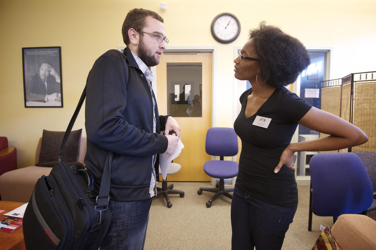 Vitaliy Stepanyuk, a student at Clark College, talks with Cetara Davis, also a student at Clark College, on Tuesday, about differences of opinion after a forum discussing a Camas couple who hung an empty chair symbolizing President Barrack Obama from a tree in their yard.