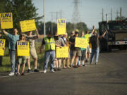 ILWU Local 4 workers and supporters hold signs at the Port of Vancouver during a rally July in Vancouver.