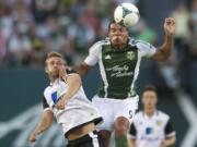 The Portland Timbers' Ryan Johnson gets to the ball before Norwich City midfielder David Fox in the first half at Jeld-Wen Field on Wednesday.