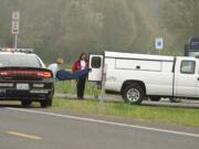 A dead body found inside a smouldering car is removed from the scene near Vancouver Lake on Monday.