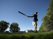 Russell MacArthur hits baseballs to a friend, Robert Straub, at Lincoln Elementary School on Monday in Vancouver.