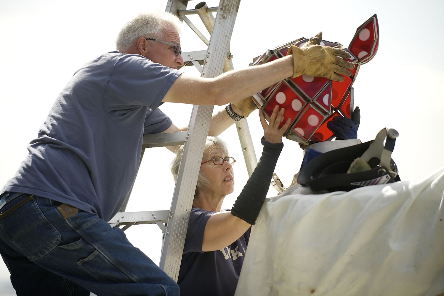 Artist Sharon Warman Agnor and her husband, Dave Agnor, carefully place the new head on the statue of &quot;Wendy Rose&quot; Tuesday morning.