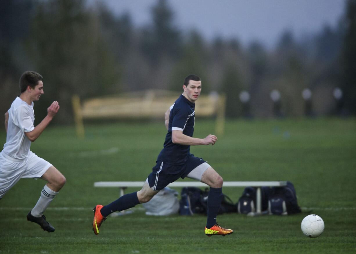 Seton Catholic's Erik Powell move the ball up field with Ridgefield's Liam Knoeppel in tow during the first half at RHS on Wednesday March 20, 2013. Ridgefield won the game 3-0.