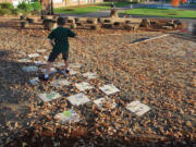 Hough Elementary School third-grader Andy Kleiner hops along tiles painted by his peers in the school's new &quot;Backyard Field Trip&quot; outdoor area.