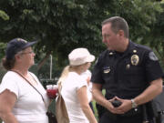 Fircrest: Vancouver Police Department Cmdr. Michael Whitney speaks with Vancouver resident Penny Ross during a Vancouver City Council-hosted community picnic and food drive on Aug.