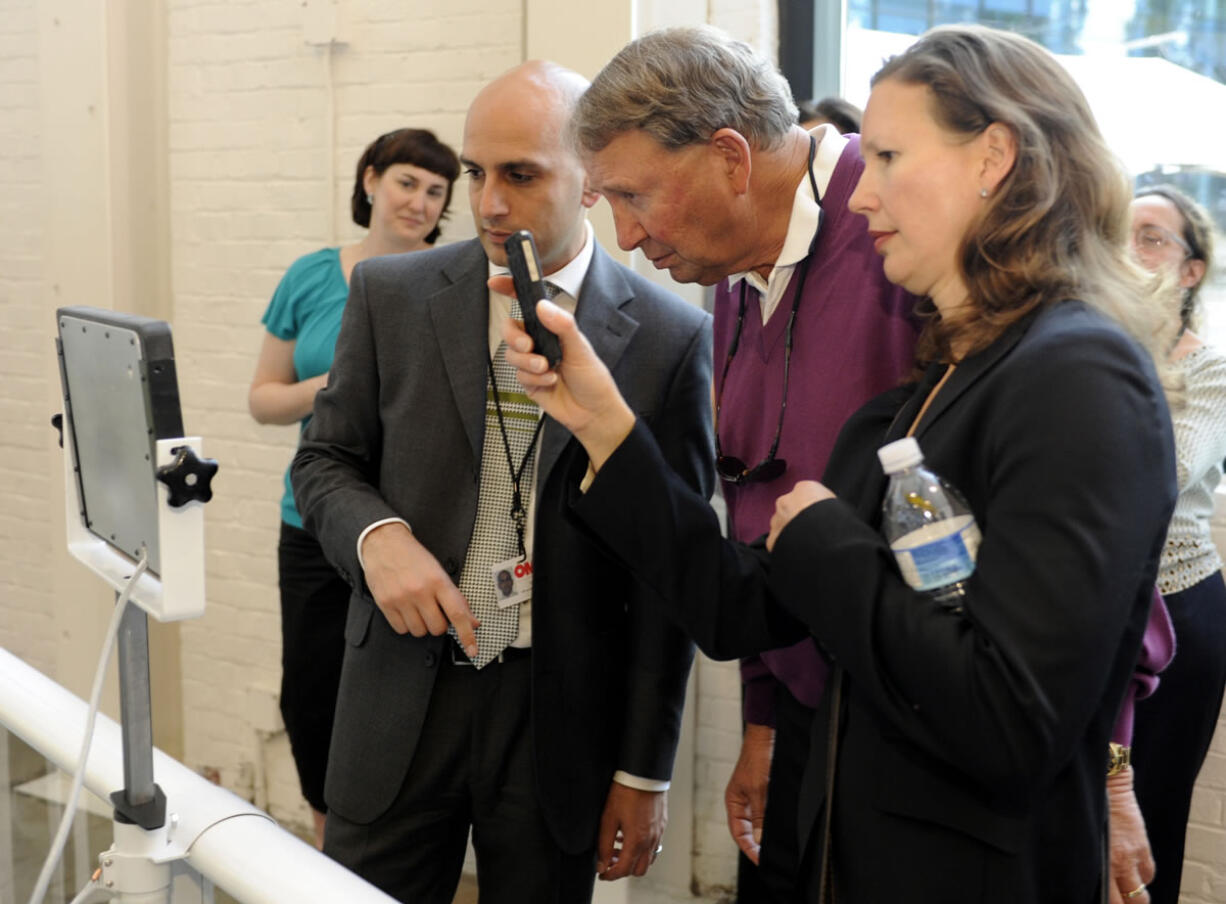 Dick Hannah, center, and Jennifer Hannah, right, speak with Mark Patel, OMSI's vice president of marketing, retailing and sales, at the Monday evening unveiling of  the 'Autovation' exhibit at OMSI.