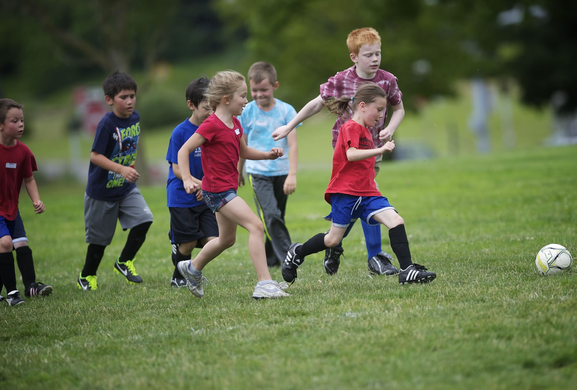 Gabrielle Briggs, 7, beats Ian York, 9, to the ball during soccer drills at a mini sports camp Thursday at Marshall Park in Vancouver.