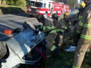 Firefighters tend to a woman injured in an auto accident this morning.