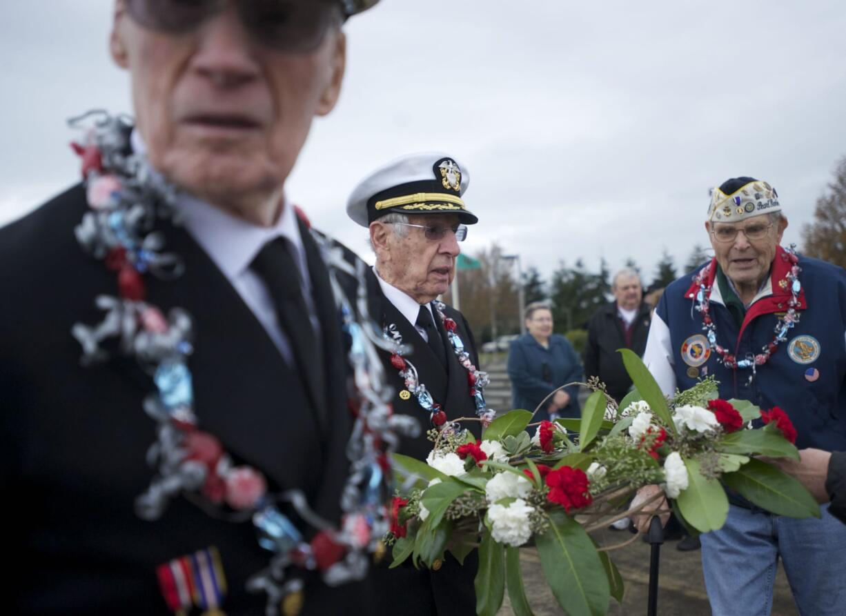 Pearl Harbor survivors Larry Lydon, from left, Ralph Laedtke and Paul Johnson prepare to cast a floral wreath into the Columbia River to commemorate the victims of the Dec.