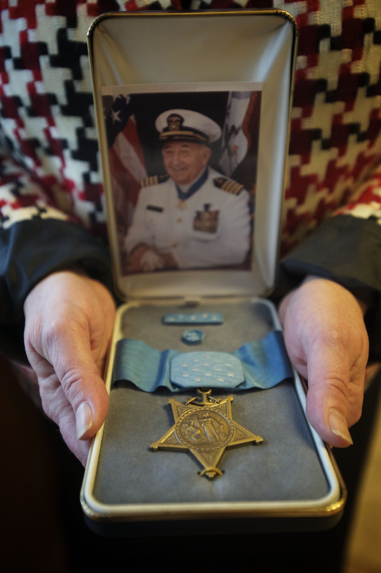 Penny Ross holds a Medal of Honor which was awarded to her father, Donald K.