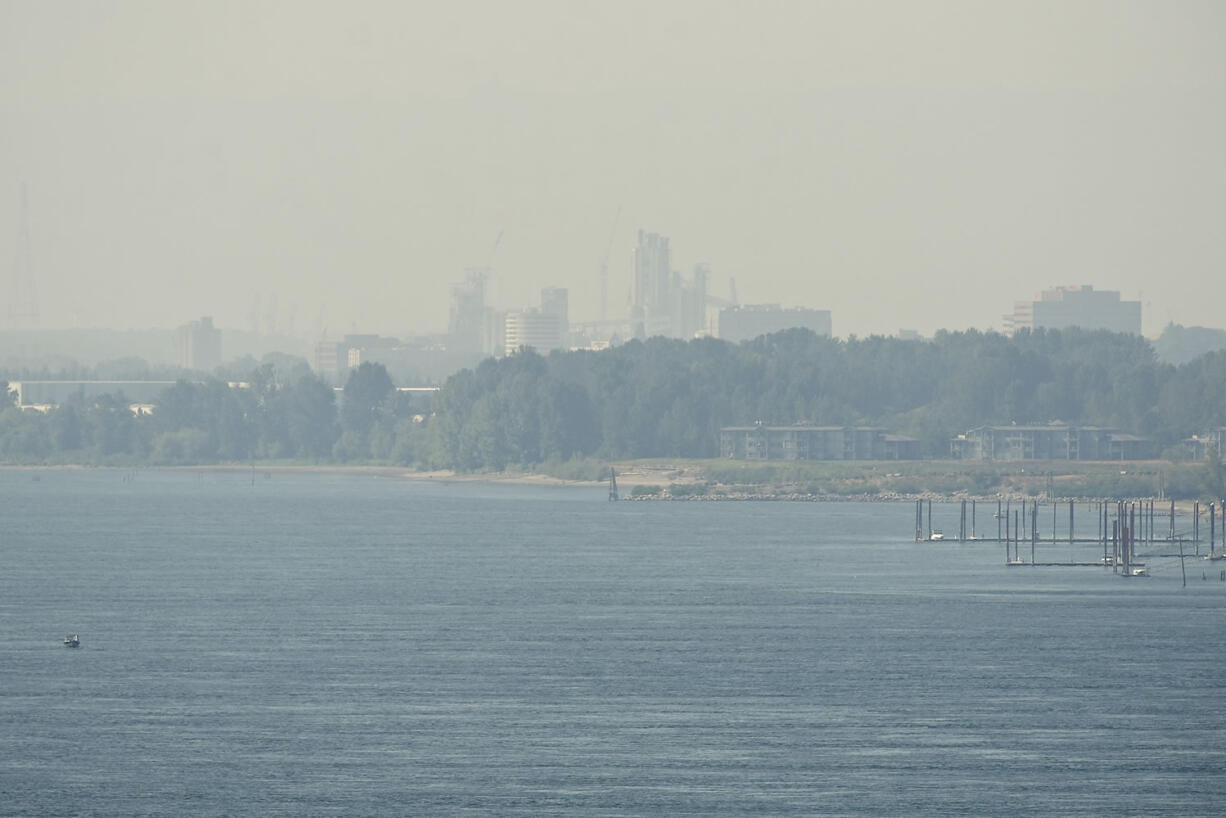 A thick haze obscures a view of the Port of Vancouver and downtown on Tuesday, as wildfires continued to burn elsewhere in the Northwest. Local officials warned of extreme fire danger due to warm, dry conditions with no end in sight.