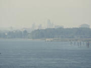 A thick haze obscures a view of the Port of Vancouver and downtown on Tuesday, as wildfires continued to burn elsewhere in the Northwest. Local officials warned of extreme fire danger due to warm, dry conditions with no end in sight.