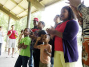 Ethell Tillis, far right, leads 6 of her 26 grandchildren, from left, Nickelas Butcher, 6, Quintin Nickelson, 15, Hfope Butcher, 12, Jabar Thomas, 4, Grace Nickelson, 14, and Fayth Butcher, 12, as they sing &quot;Oh Happy Day&quot; on Saturday at the Juneteenth celebration at Marine Park in Vancouver.