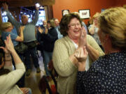 Vicki Sparks, left, with Citizens for Better Schools, celebrates with Cathy Golik, right, as election returns show victory for the Battle Ground school levy Tuesday.