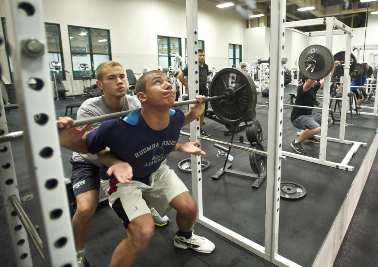 Evergreen High School's Jared Marshall spots fellow senior Trent Foster as he does squats with 285 pounds of free weights. The buddies leave for Marine Corps boot camp on Aug.