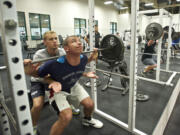 Evergreen High School's Jared Marshall spots fellow senior Trent Foster as he does squats with 285 pounds of free weights. The buddies leave for Marine Corps boot camp on Aug.