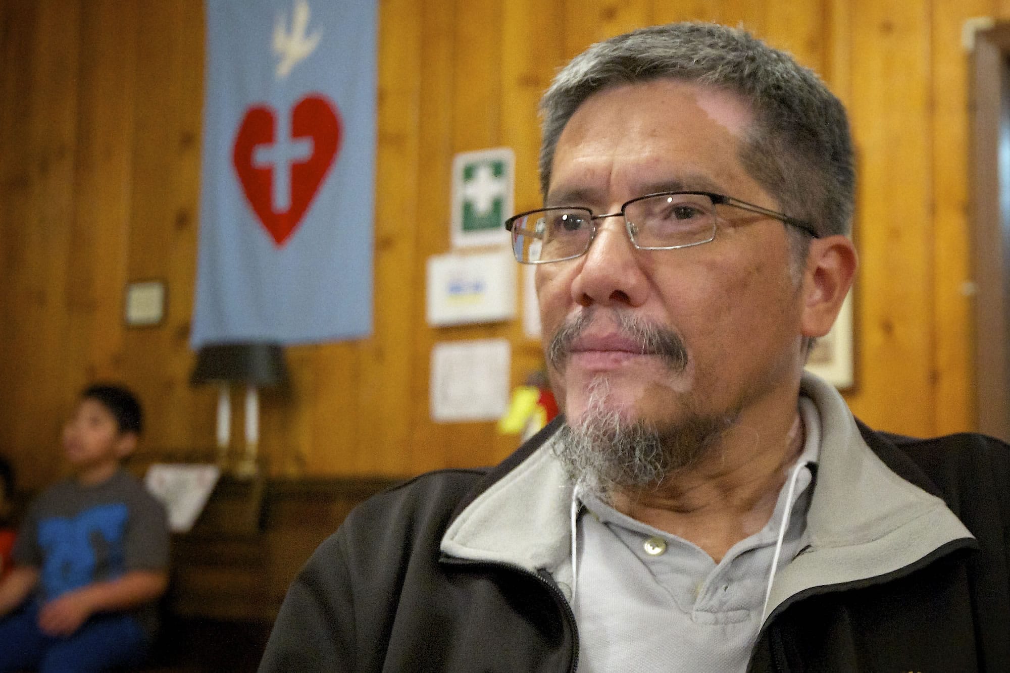 David Ayala-Zamora, an organizing director for OneAmerica, listens to speakers at a rally Tuesday at St.