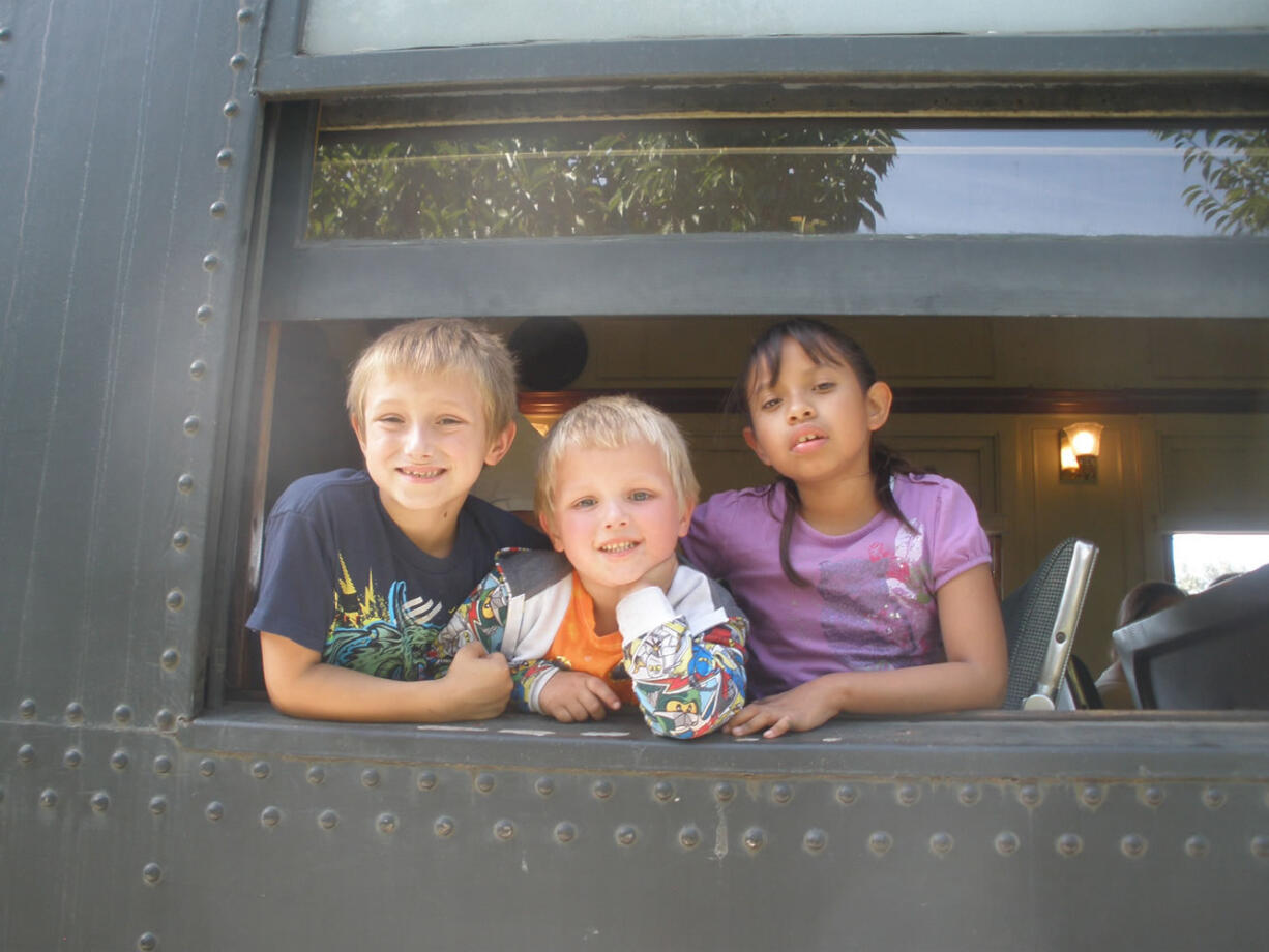 Orchards: Skyler Sheffield, left, Jayden Sheffield and Fabiola Rico Castillo ride the Mount Hood Railroad to Parkdale, Ore. with the Modern Woodmen of Americais Youth Service Club on Sept.