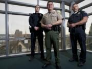 Portland police Sgt. Peter Simpson, from left, Clark County sheriff's Deputy Tim Hockett and Vancouver police Officer Taylor Smarr all stand to benefit from a regionwide records-management system that is planned to launch in November 2014.