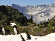 Boundary Trail No. 1 carves through patches of snow between evergreen trees and rocks near Mount St.