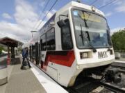 Passengers board a TriMet MAX light-rail train at the Delta Park/Vanport light-rail transit station. A Cowlitz County judge Wednesday delayed until March a decision on a lawsuit over a state law that says if a person signs a petition more than once, all their signatures must be rejected.