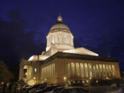 The Washington state Capitol is lit against a late-evening sky in Olympia.