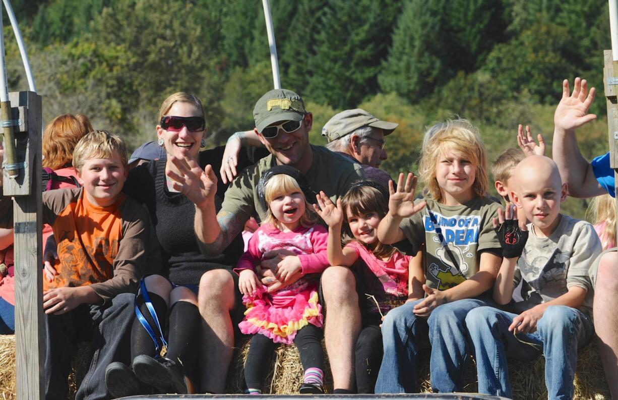 From left, Joziah Mattison, Sumer Mattison, Jake Mattison, holding Lola, then Lily, Mekhi and Kamren Mattison head to the pumpkin patch at the Pomeroy Living History Farm in Yacolt, Wa., Sunday Oct., 7 2012.