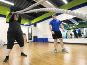 Laina Harris performs a resistance workout as fitness trainer Cody Sorensen gives instruction during a personal training session Thursday at Body Design Fitness in Camas.