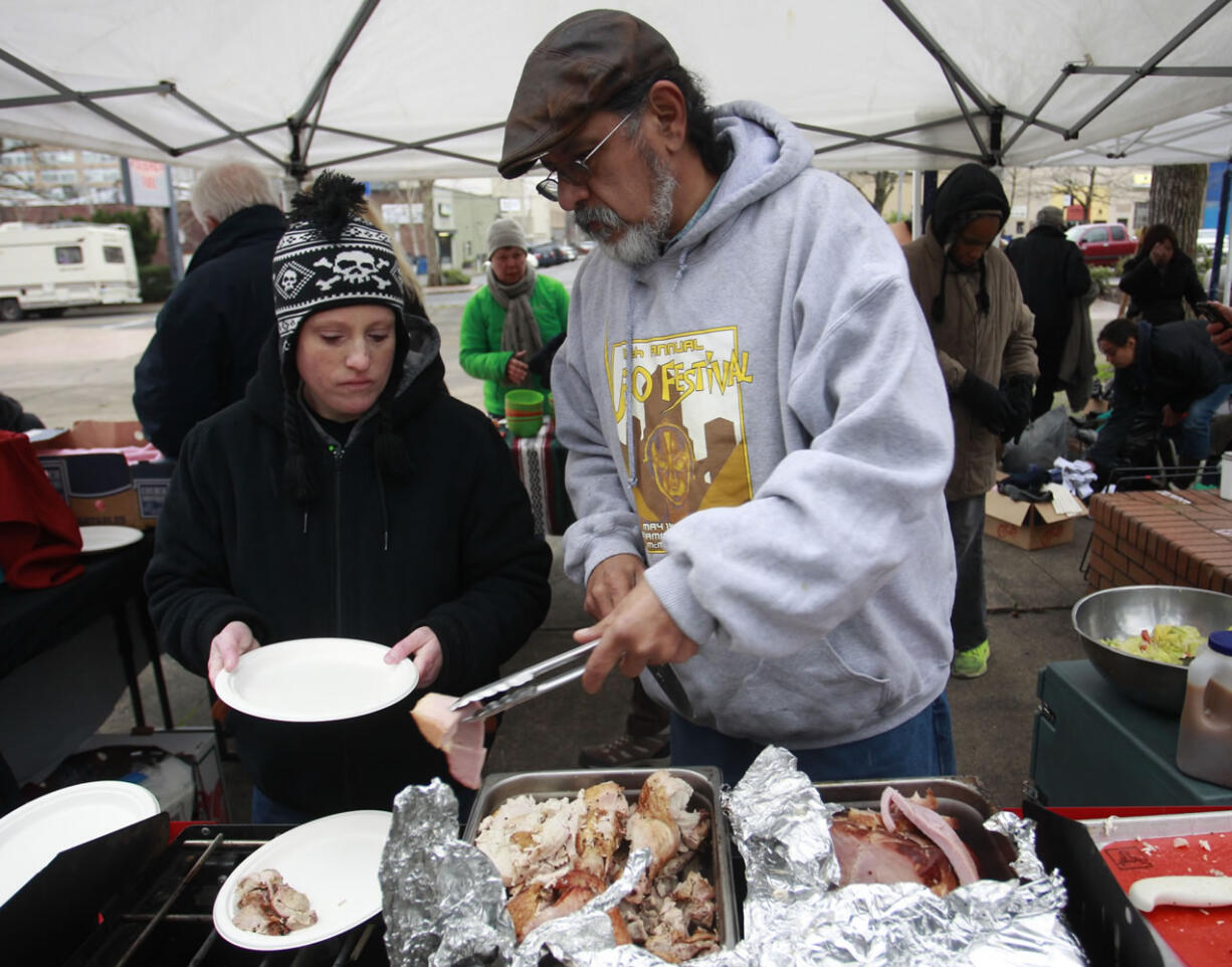 Erica Marchbank, left, and Hector Hinojosa dish up a free Stone Soup Community Meal on Sunday in downtown Vancouver.