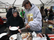 Erica Marchbank, left, and Hector Hinojosa dish up a free Stone Soup Community Meal on Sunday in downtown Vancouver.